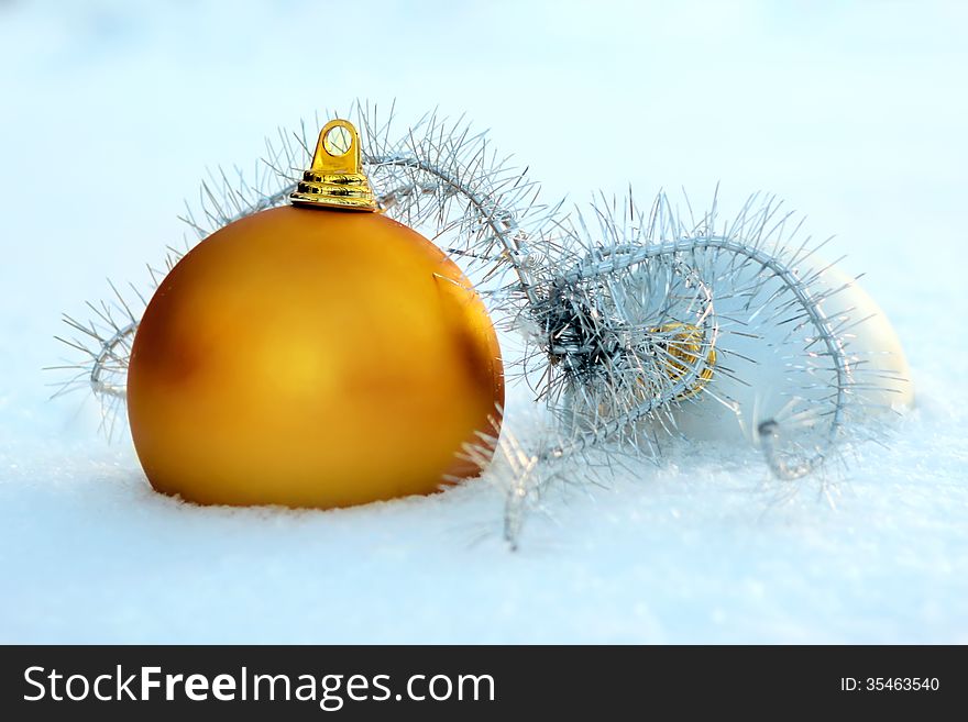 Golden and silver christmas balls in snow
