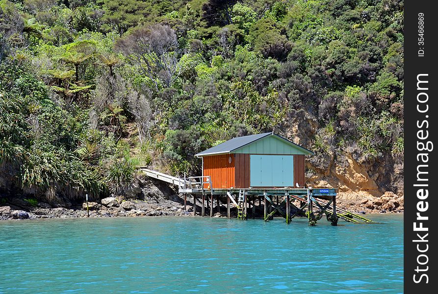 Classic boat house and jetty on the rocky shores of the Marlborough Sounds, New Zealand. Classic boat house and jetty on the rocky shores of the Marlborough Sounds, New Zealand.