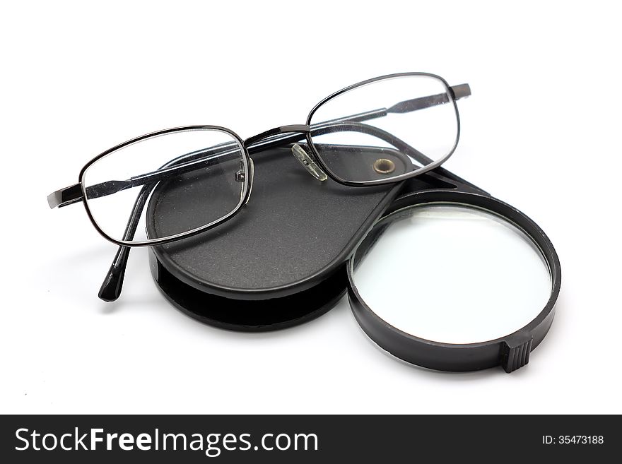 Eye glasses and magnifying glass isolated on white background
