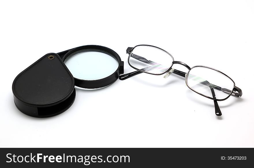 Eye glasses and magnifying glass isolated on white background