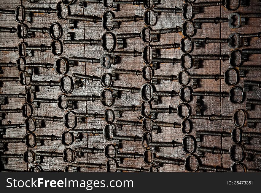 Old metal keys set aligned in wood. Old metal keys set aligned in wood.