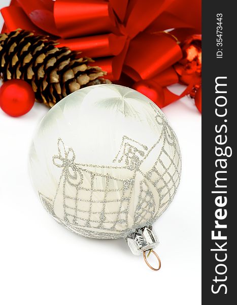 Handmade White Silk Christmas Ball with Silver Decoration on Holiday Ribbons and Baubles background closeup