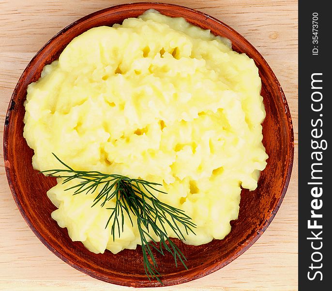 Homemade Mashed Potato in Brown Bowl Garnished with Dill. Top View