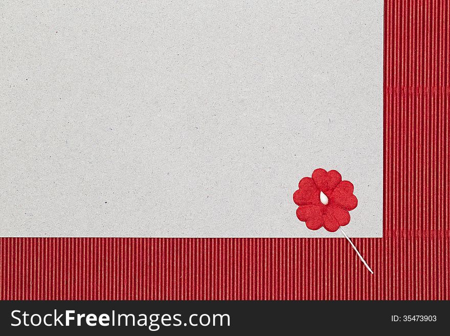Cardboard background with paper flower, red color