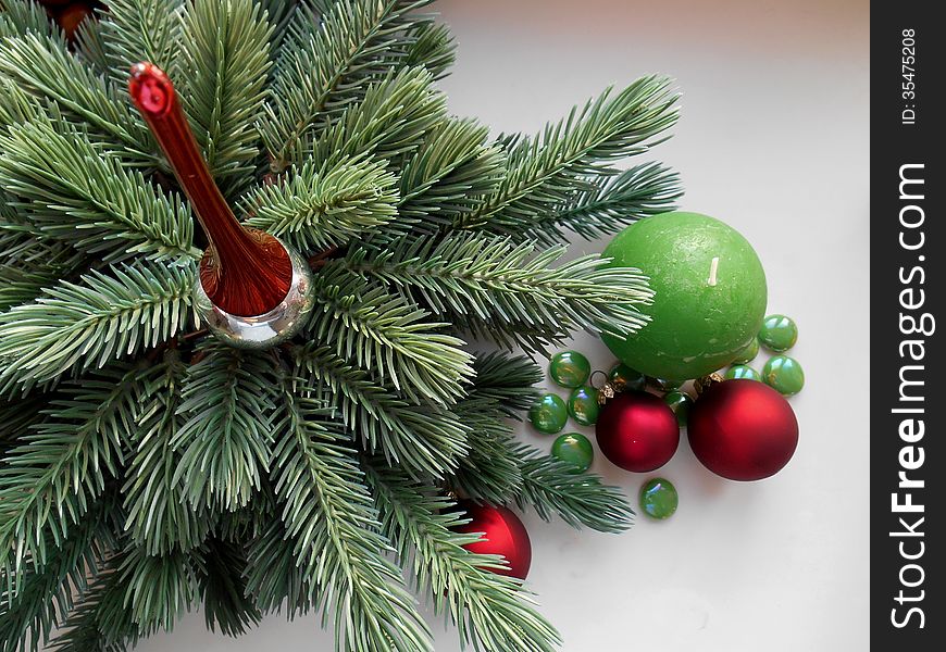 Christmas and New Year decorations red balls firtree and green candle and stones. Christmas and New Year decorations red balls firtree and green candle and stones