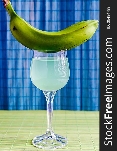 Cocktail with green banana on the glass