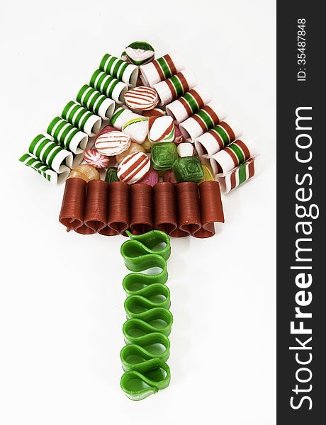 Christmas tree formed with Christmas ribbon and hard candies against a white background. Christmas tree formed with Christmas ribbon and hard candies against a white background