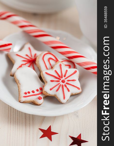 A cup of milk, Christmas cookies and candy on a white wooden background
