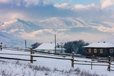 Snow-covered Mountains Behind Two Cotteges Royalty Free Stock Images