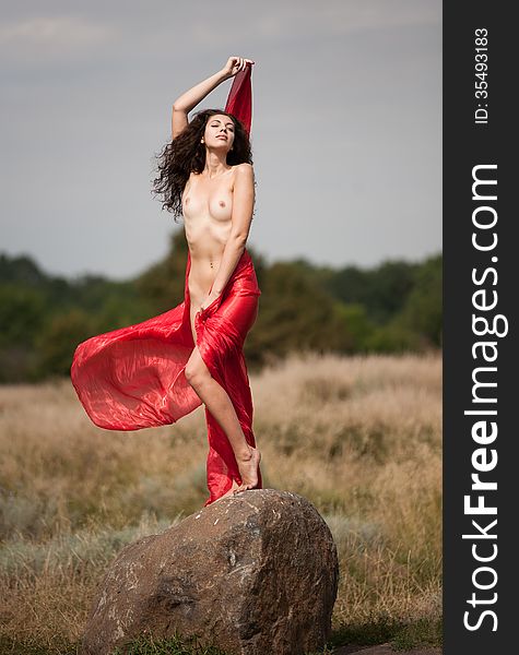 Naked Brunette In A Red Cloak On A Stone