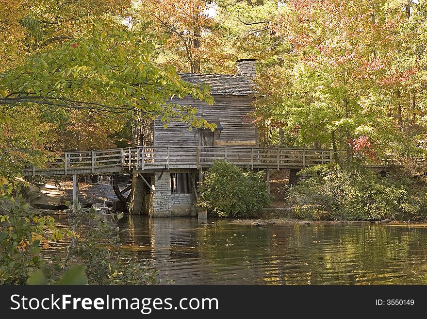 An old mill on the edge of a serene lake. An old mill on the edge of a serene lake