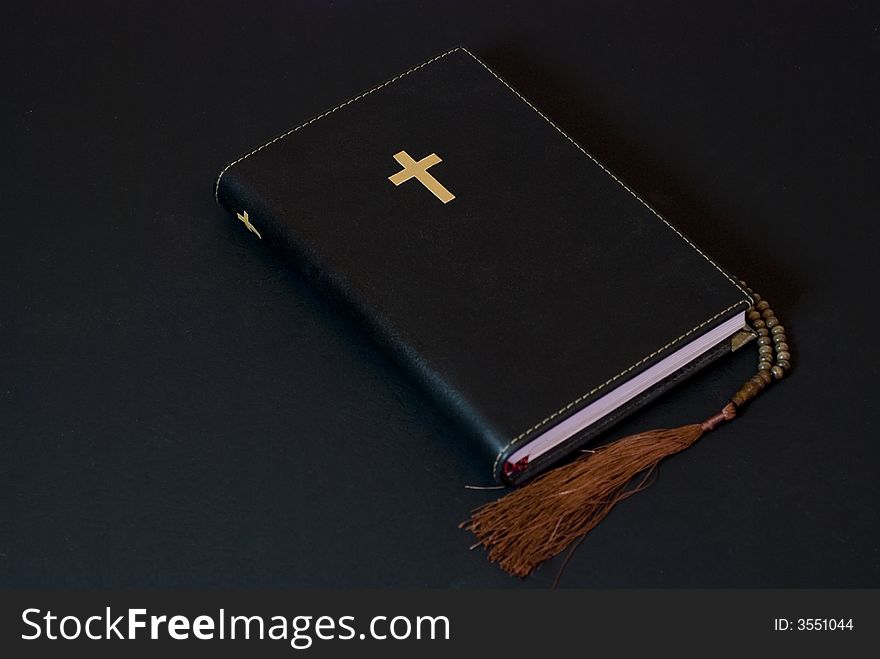 Leather bible on the ground against black background