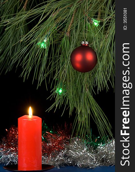 Decorated christmas tree and a lit red candle. Decorated christmas tree and a lit red candle