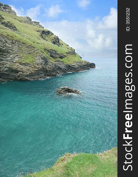 The rugged coast of cornwall UK with blue  skies and green ocean. The rugged coast of cornwall UK with blue  skies and green ocean