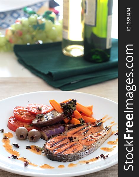 Pan seared salmon served with brinjal, carrots, sliced tomatoes and white wine