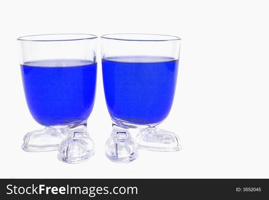 Two glass whit blue liquid one a white background. Two glass whit blue liquid one a white background