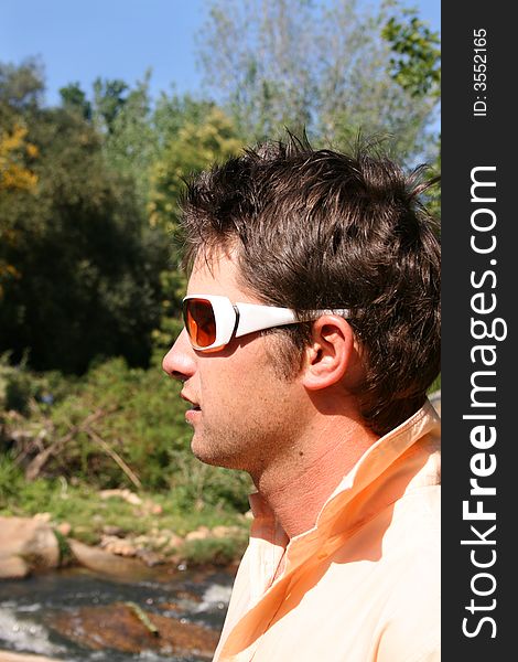Profile of a young male model wearing white sunglasses. Profile of a young male model wearing white sunglasses