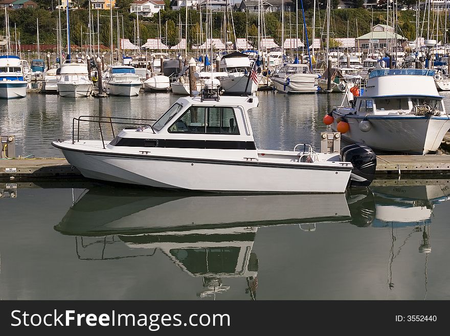 A white motor boat at a busy marina. A white motor boat at a busy marina