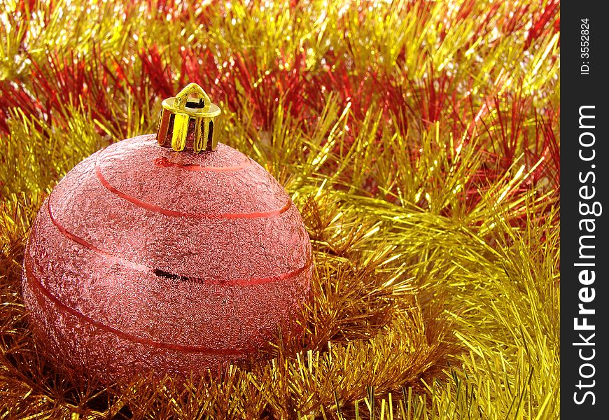Red christmas bauble with golden tinsel