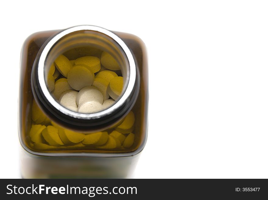 Upper view of a bottle full of white pills against white background. Upper view of a bottle full of white pills against white background