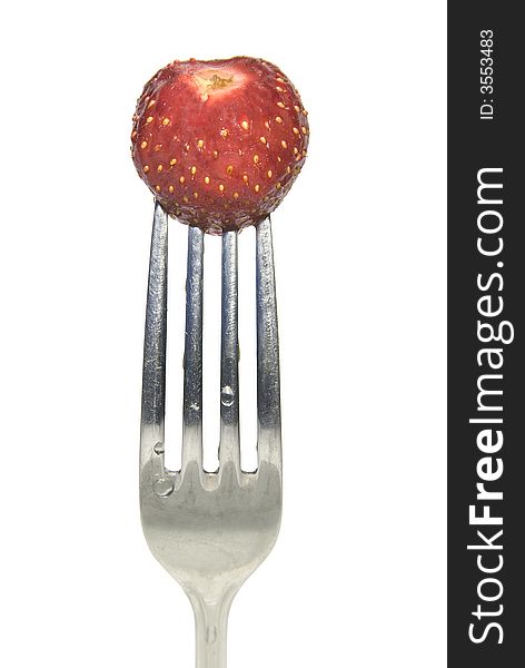 Close up of a red strawberry on a fork against white background. Close up of a red strawberry on a fork against white background