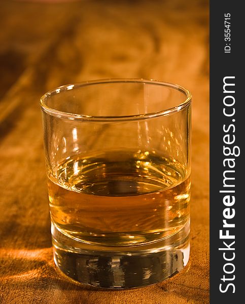 A glass of whisky in warm colored setting. A glass of whisky in warm colored setting