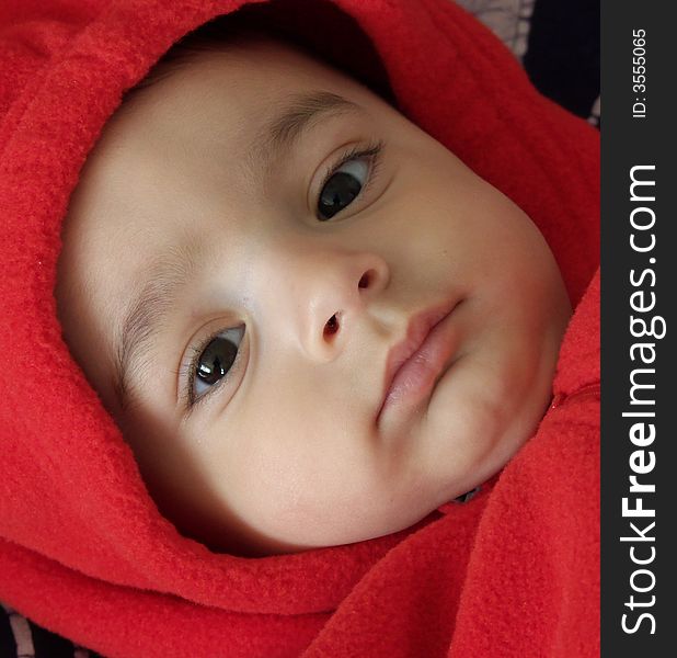 Six month old baby in red fleece hood. Six month old baby in red fleece hood