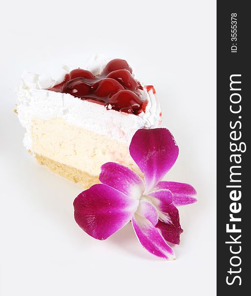 Piece of cream cherry cake and flowers isolated on white. Piece of cream cherry cake and flowers isolated on white.