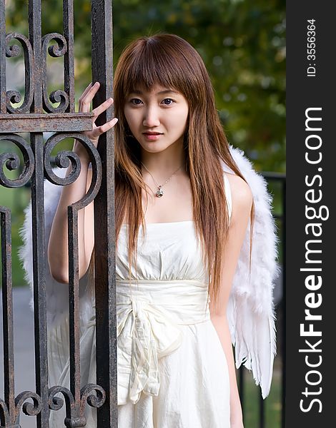 A girl wearing a angel wing posing on campus. A girl wearing a angel wing posing on campus