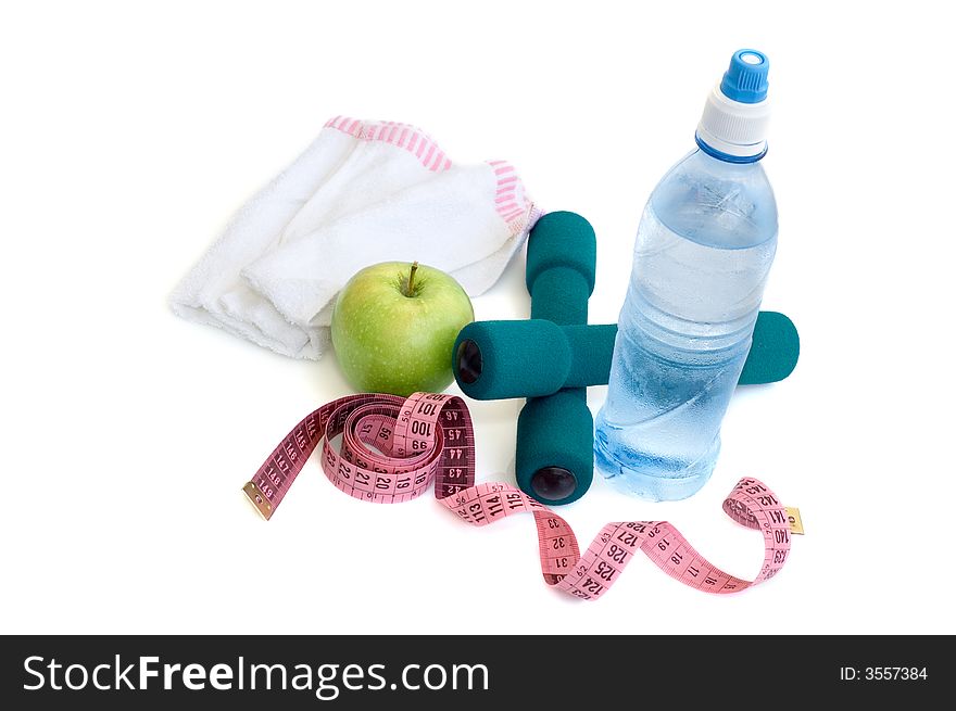 Dumbells, apple and measuring tape on a white background