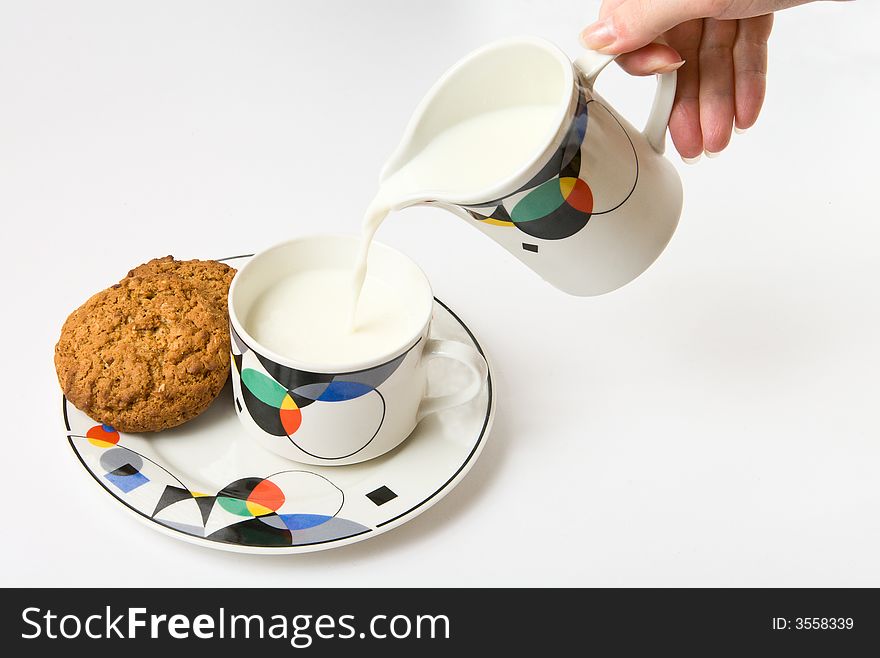 Woman, pouring milk to cup on white