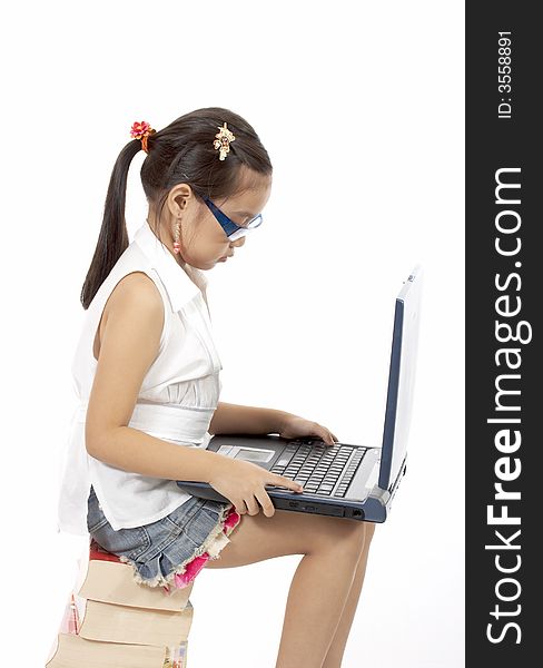 A young girl typing on a laptop. A young girl typing on a laptop