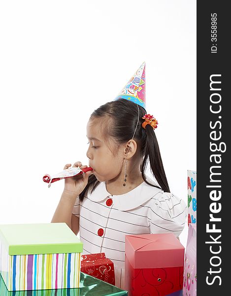 A girl wearing a party hat over a white background. A girl wearing a party hat over a white background