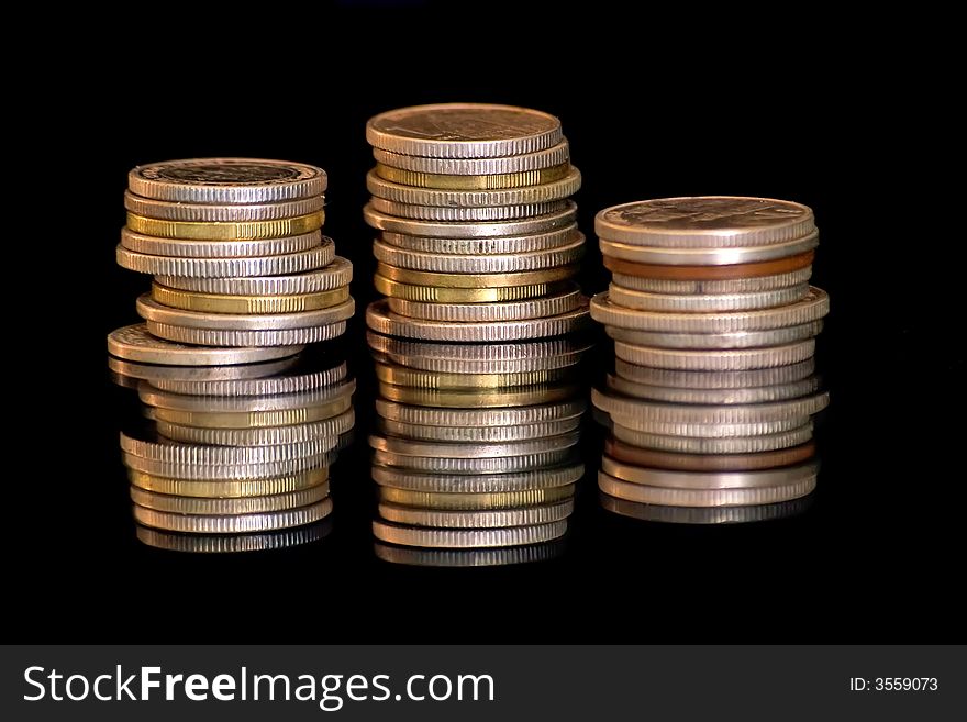 Silver and gold coins isolated on black background.