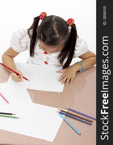 A young girl drawing on a white piece of paper