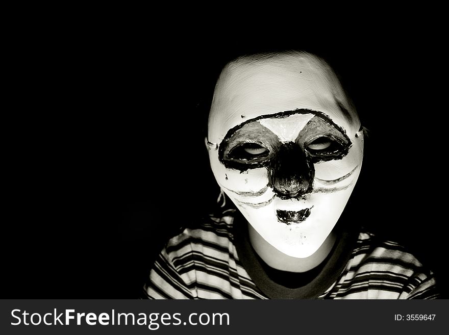 Boy with a halloween mask, isolated on black