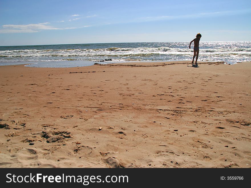 Little boy plays on a seaside sand, Baltic sea, Latvia. Little boy plays on a seaside sand, Baltic sea, Latvia