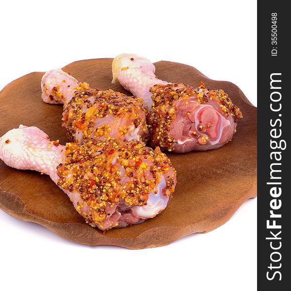 Three Raw Chicken Drumsticks Marinated with Whole Grain Mustard closeup on Wooden Plate on white background. Three Raw Chicken Drumsticks Marinated with Whole Grain Mustard closeup on Wooden Plate on white background