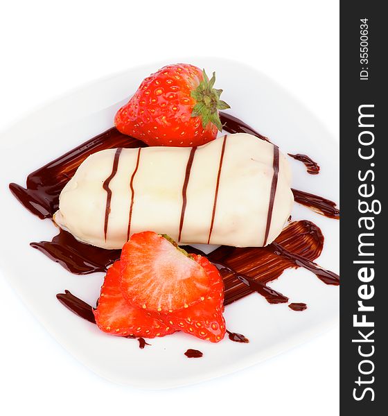 Arrangement of White Chocolate Eclair with Chocolate Sauce and Sliced Strawberry on White Plate closeup on white background