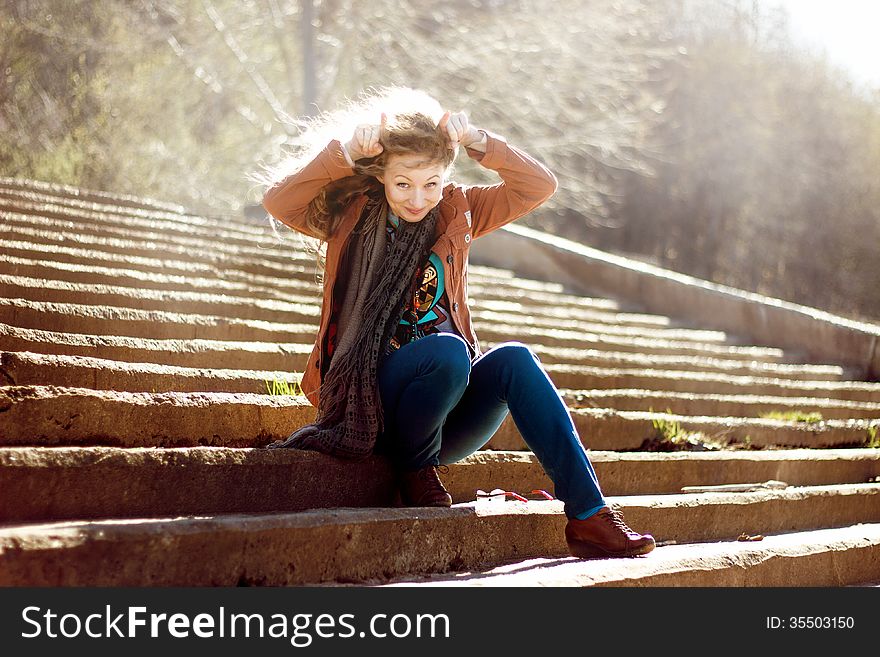 Funny Woman With Blonde Curly Hair On Stairs Background