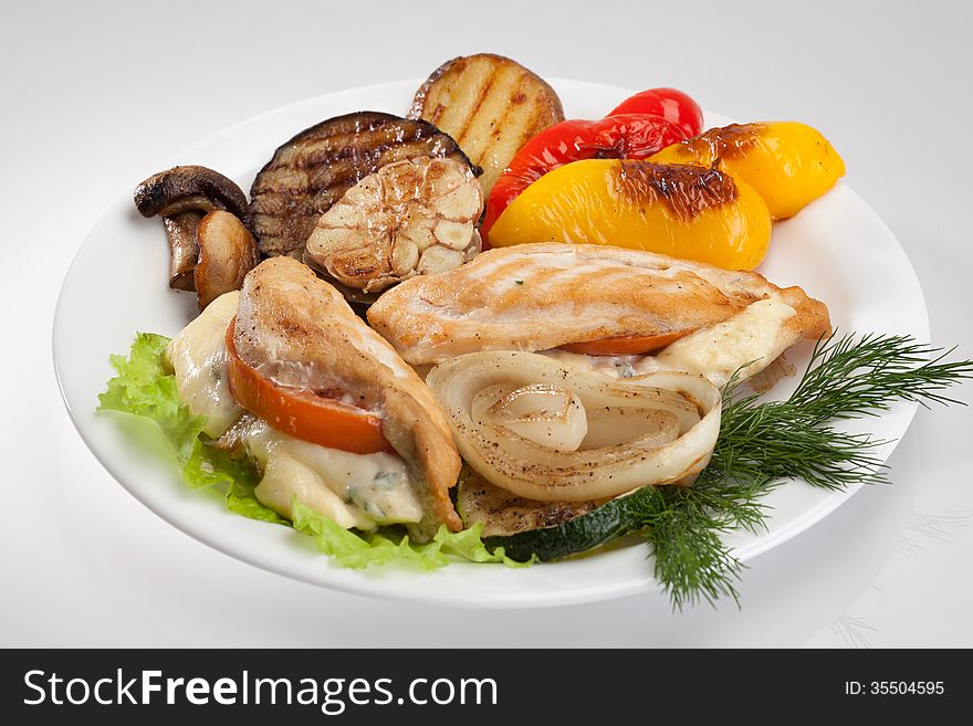 Grilled chicken on a plate with potatoes, pepper, dill and onions on a plate isolated on white background. Grilled chicken on a plate with potatoes, pepper, dill and onions on a plate isolated on white background