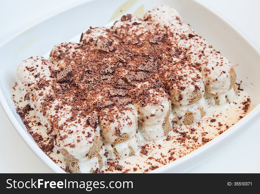 Tiramisu Italian cake on a plate closeup isolated on white. Tiramisu Italian cake on a plate closeup isolated on white