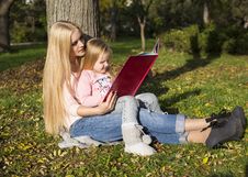 Mother And Her Little Girl Reading Book Stock Image