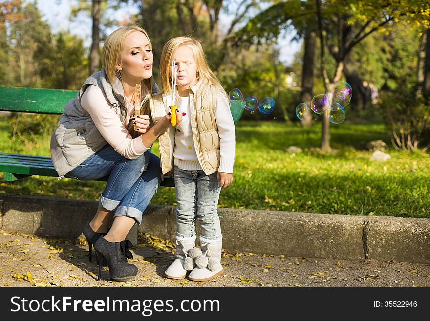 Mother and her little kid with soap bubbles