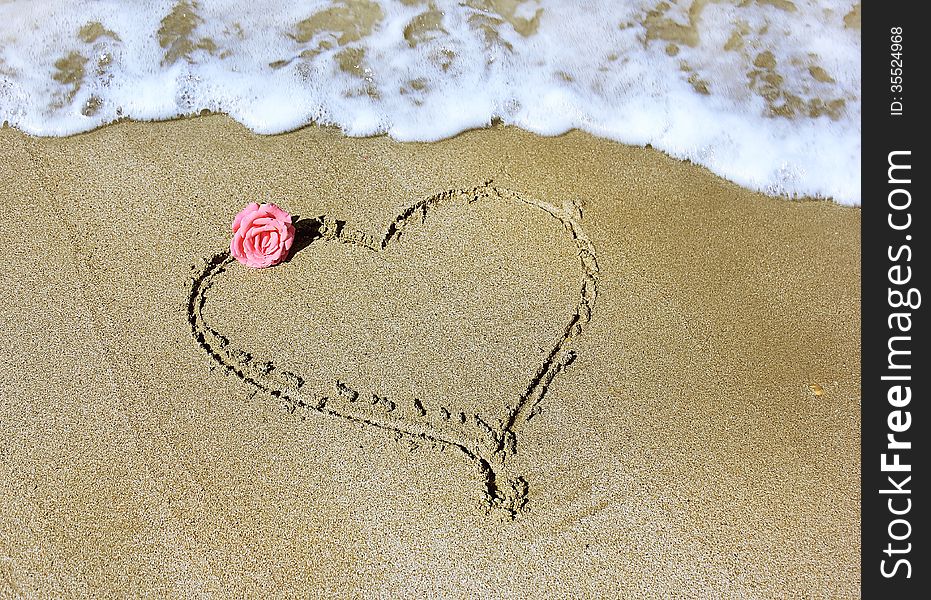 Drawing a heart with rose on sandy beaches of the Mediterranean. Drawing a heart with rose on sandy beaches of the Mediterranean
