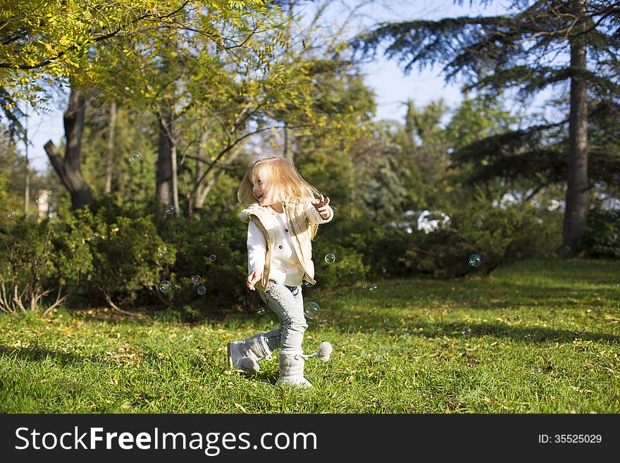Funny little girl with soap bubbles