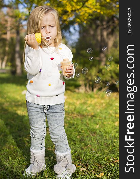 Funny little girl with soap bubbles