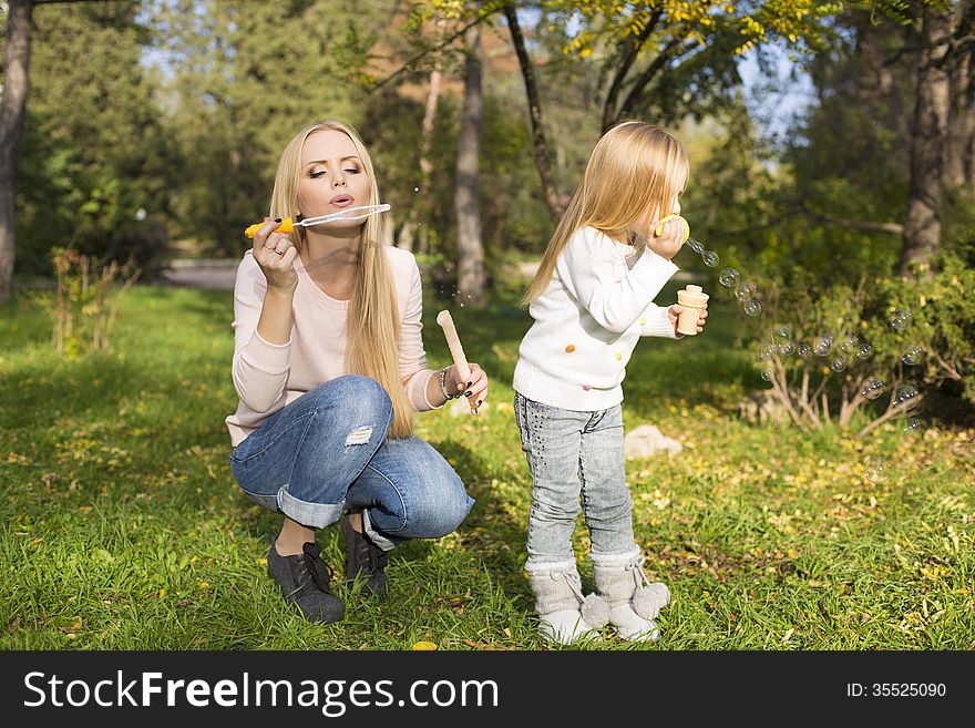 Happy family with soap bubbles in park. Happy family with soap bubbles in park