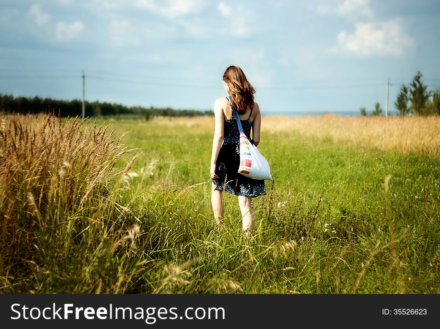 Woman walking through green and yellow corn field. Woman walking through green and yellow corn field