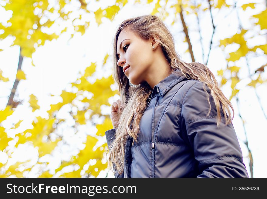 Gorgeous young woman on yellow autumn leaves background